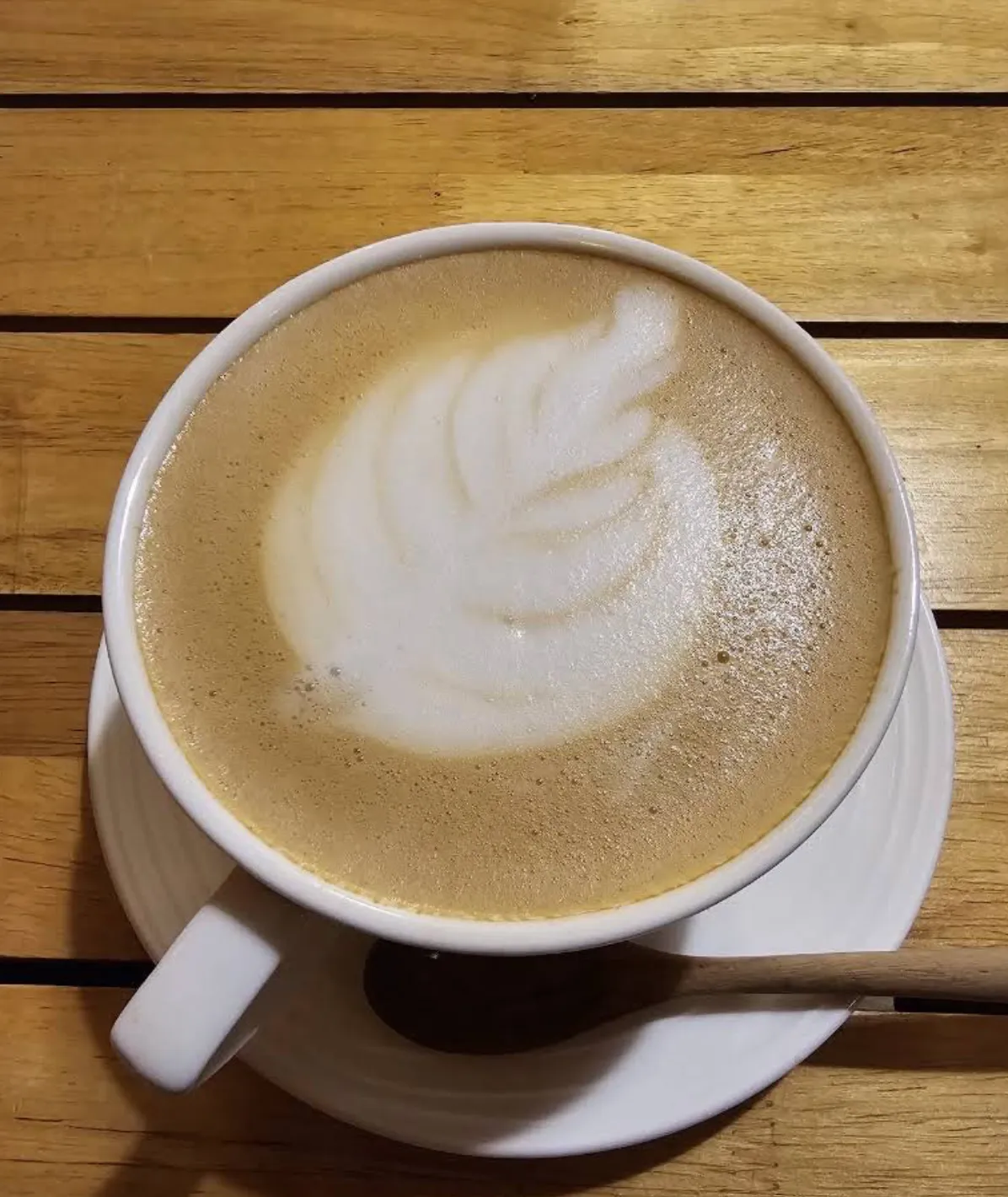 Café latte with latte art on a wooden table